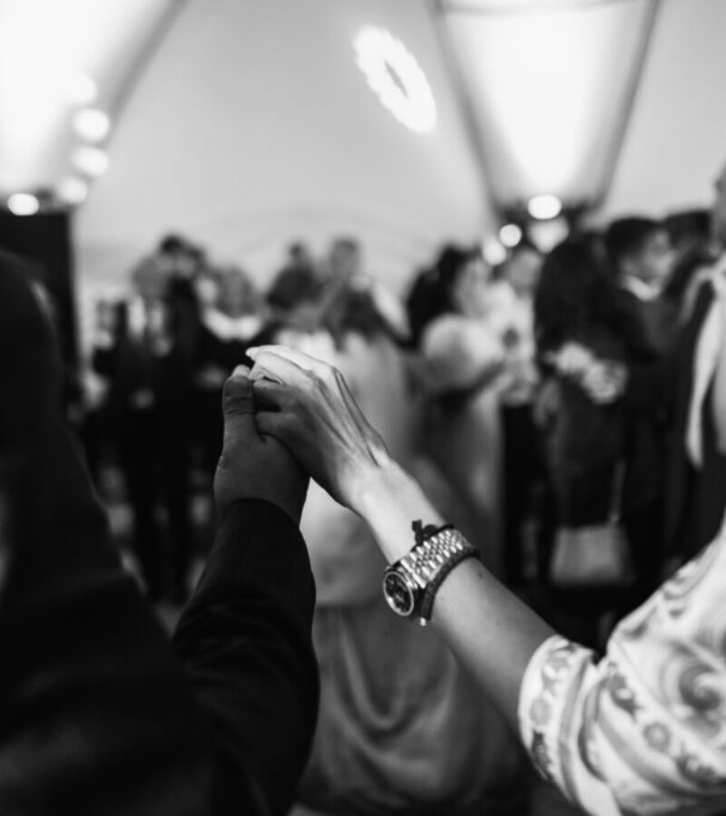 Man and woman hold their hands up while dancing